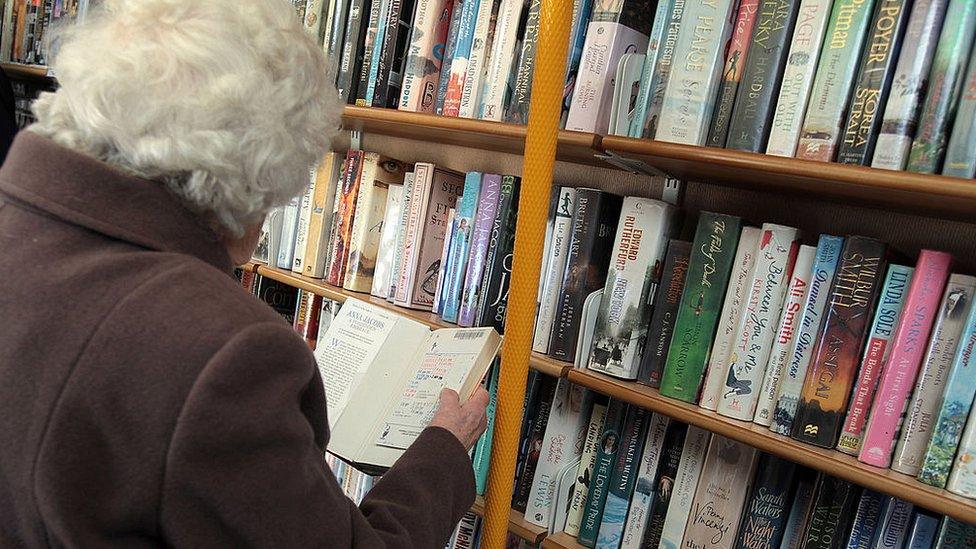 woman reading book at library