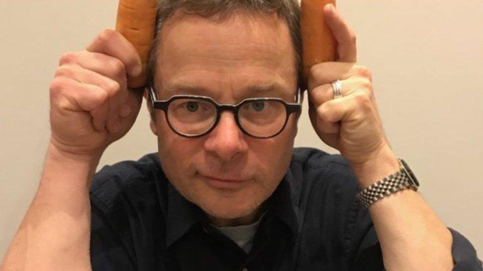 Hugh Fearnley-Whittingstall holding carrots to his head.