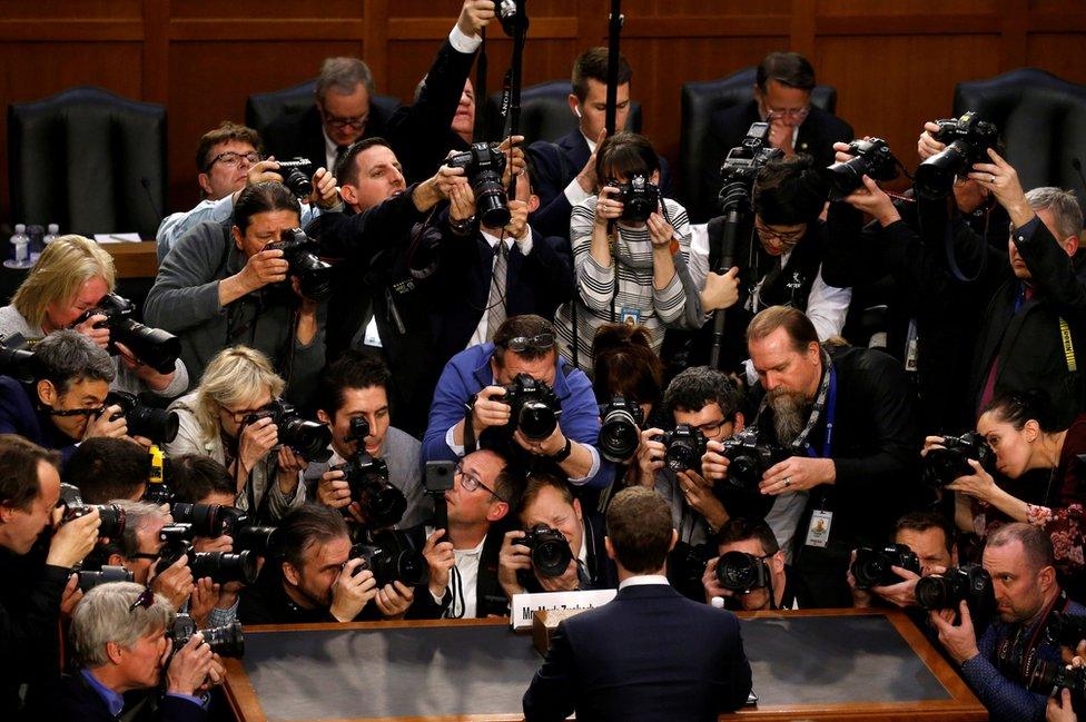 Facebook CEO Mark Zuckerberg is surrounded by members of the media.