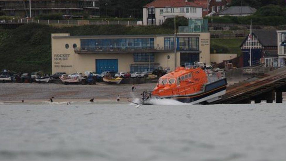 A lifeboat launching from Cromer's lifeboat house and slipway