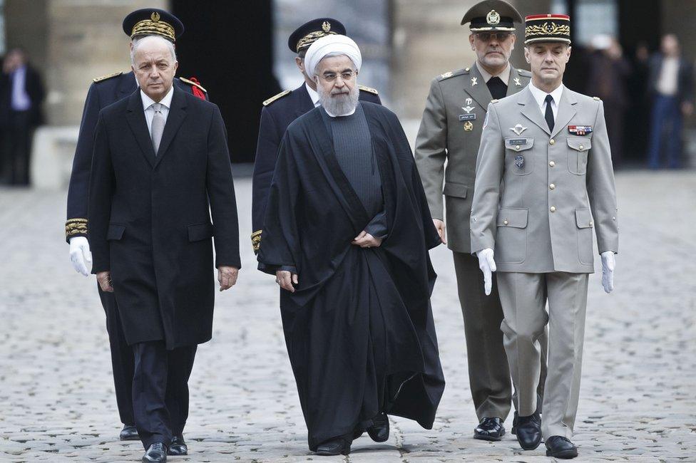 French Foreign Minister Laurent Fabius, left, and Iranian President Hassan Rouhani arrive for a welcome ceremony at the Invalides in Paris