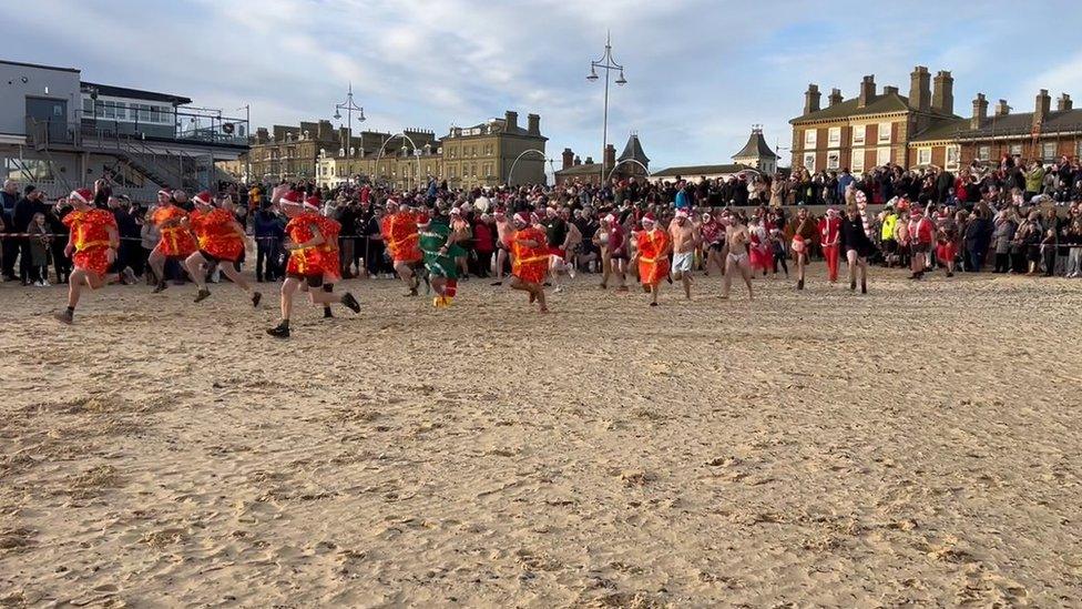 Swimmers in fancy dress taking part in a Christmas Day swim in Lowestoft