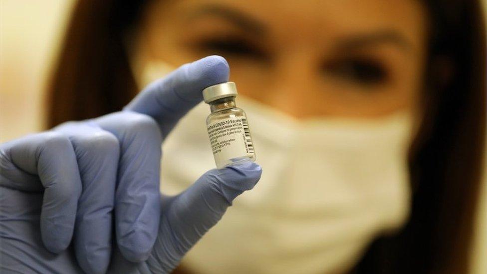 A nurse with vial of Pfizer vaccine