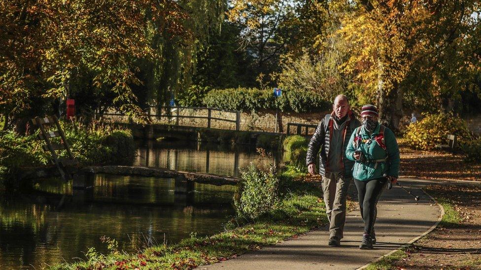 Two people walking near a river