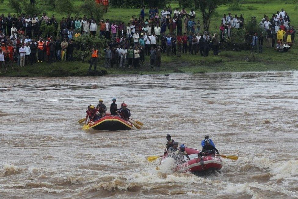 Rescue workers search the flooded River Savitri after an old bridge collapsed in Mahad, western Maharashtra state, India, Wednesday, Aug. 3, 2016.