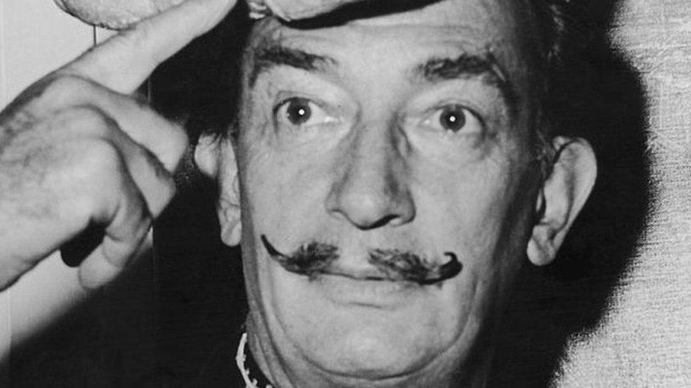 Spanish surrealist artist Salvador Dali wears a hat shaped like a loaf of bread on his head, 5 November 1958