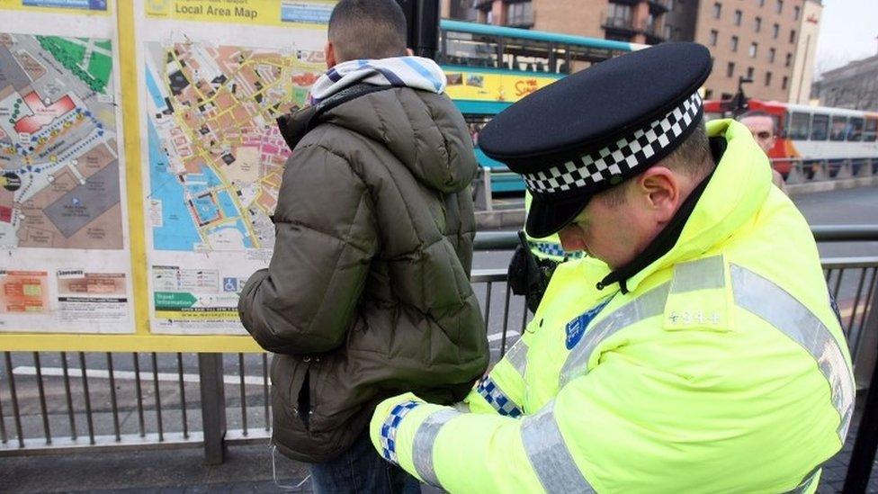 Police officer searching man in Liverpool