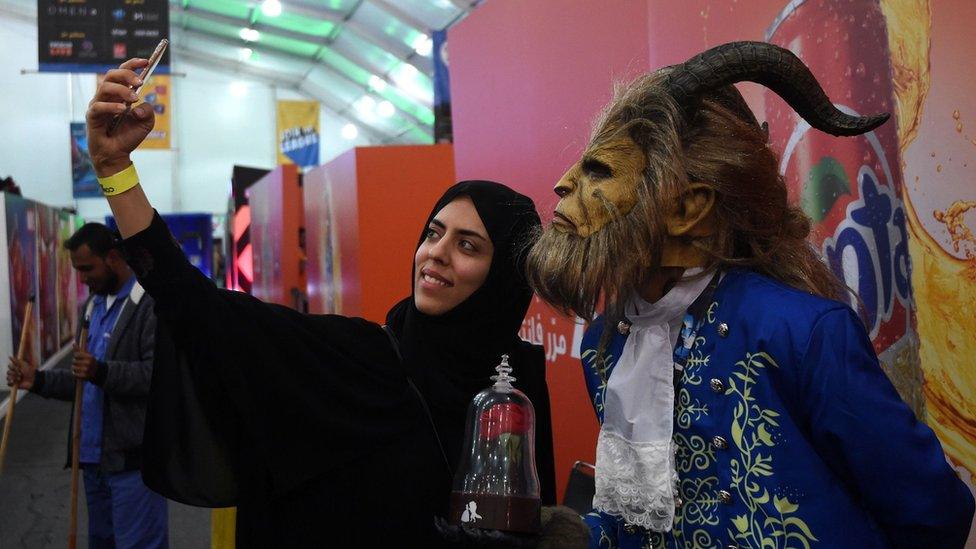 A Saudi woman takes a selfie with person dressed as the Beast from Disney's 2017 Beauty And The Beast film at a Comic Con Arabia event Riyadh on 25 November 2017