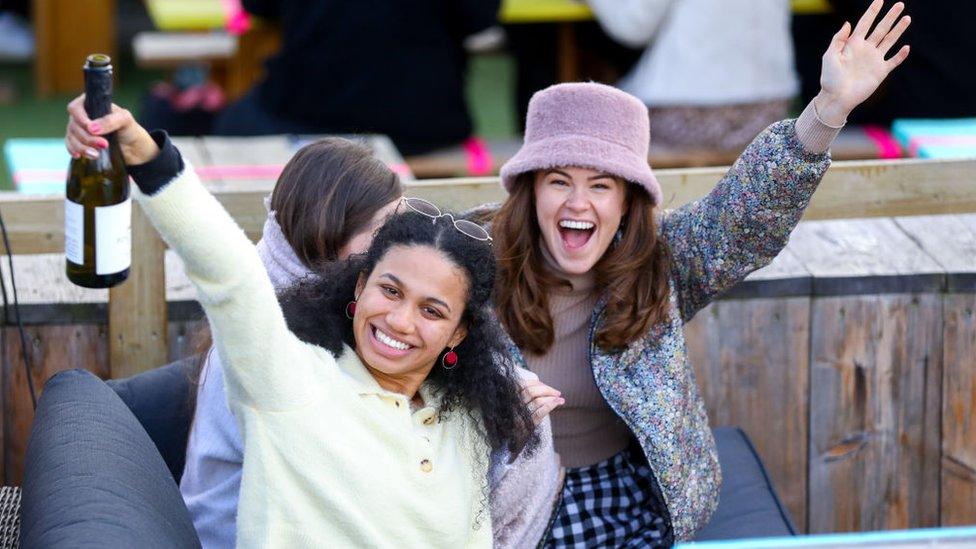 Two friends enjoy a celebratory drink at The Skylight roof top bar in London