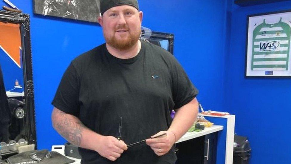 Hairdresser Lance Wells standing in the shop where he works