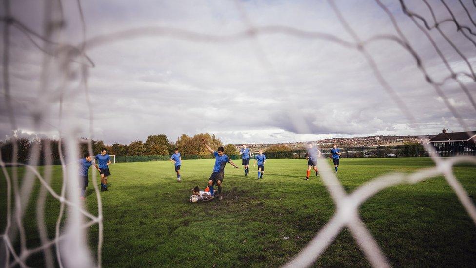 A goalkeeper tackling a striker from the goal mouth