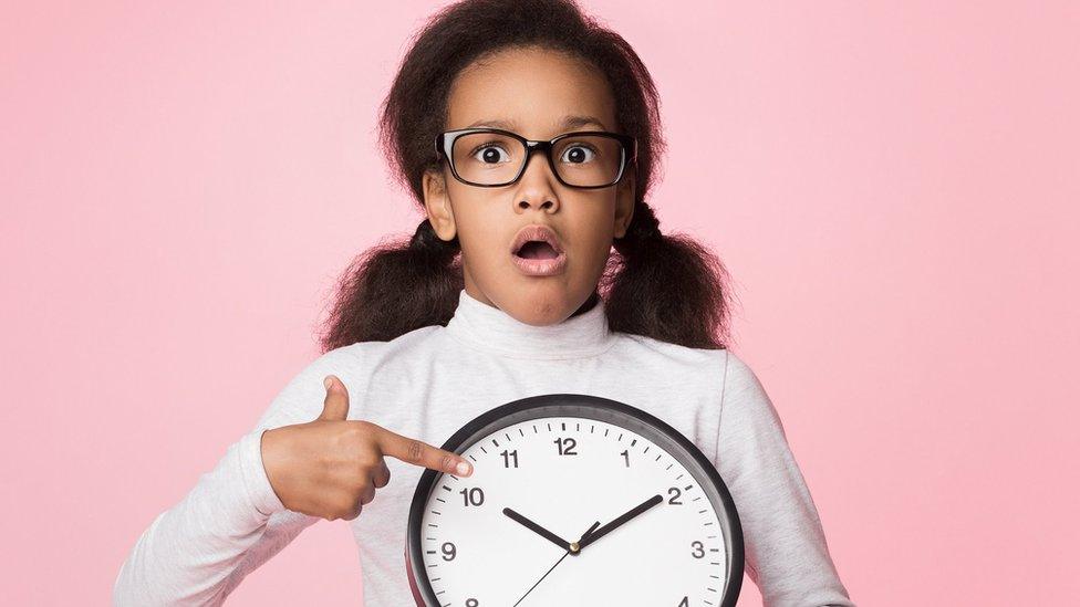 A child is amazed by a clock