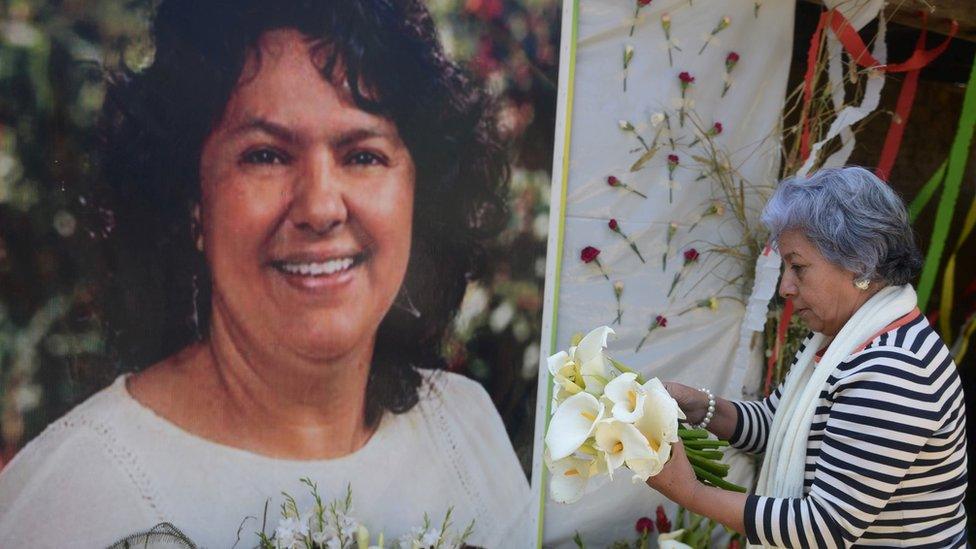 The president of the NGO Committee of Relatives of the Disappeared in Honduras, Bertha Oliva, lays a wreath on an alter in memory of murdered indigenous Honduran environmentalist Berta Caceres