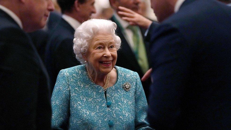 Britain's Queen Elizabeth II (C) and Britain's Prime Minister Boris Johnson (L) greet guests during a reception to mark the Global Investment Summit, at Windsor Castle in Windsor, west of London on October 19, 2021