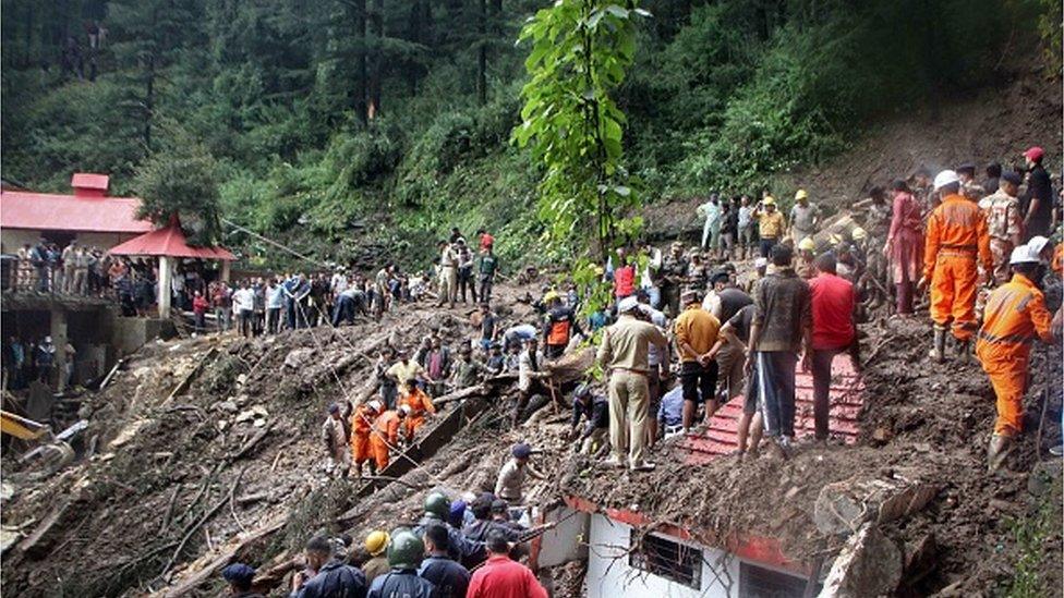 National Disaster Response Force (NDRF) personnel search for victims at the site of a landslide after a temple collapsed due to heavy rains in Shimla on August 14, 2023.