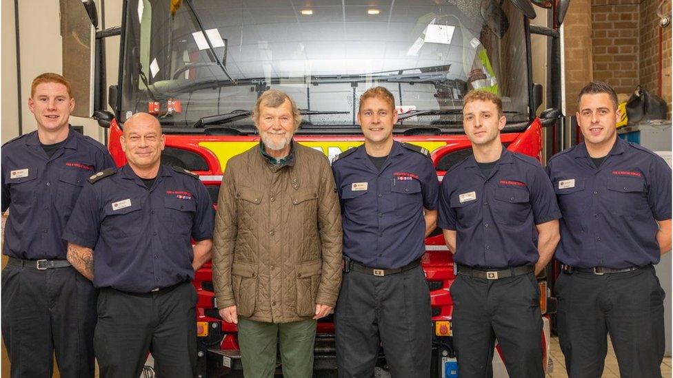 A group of people in front of a fire truck