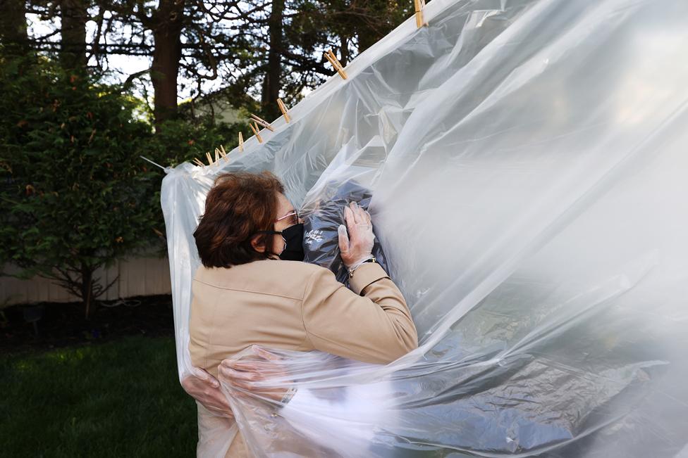 A mother and daughter embrace through a plastic sheet in Wantagh, New York, on 24 May 2020