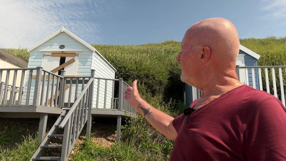 Paul Major near a damaged beach hut