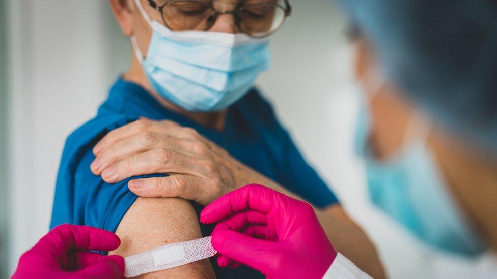 Nurse putting plaster on patient's arm