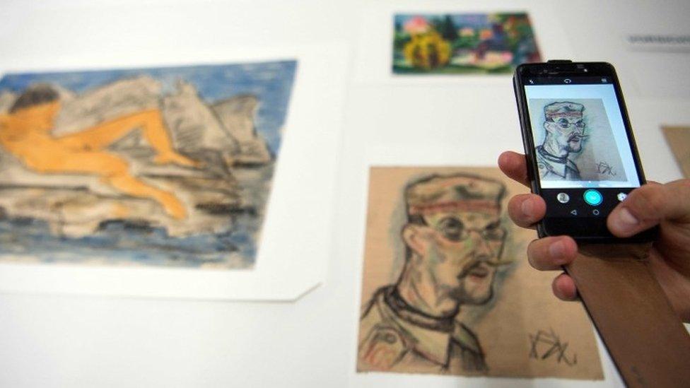 A journalist takes a picture with a mobile phone of the art pieces coming from the estate of German collector Cornelius Gurlitt during a press preview of the first masterpieces of the estate of Gurlitt at the Museum of Fine Arts Bern (07 July 2017)