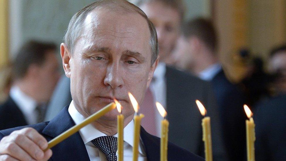 A picture of Vladimir Putin lighting candles