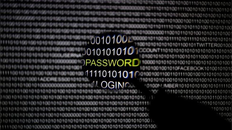 A magnifying glass is held in front of a computer screen