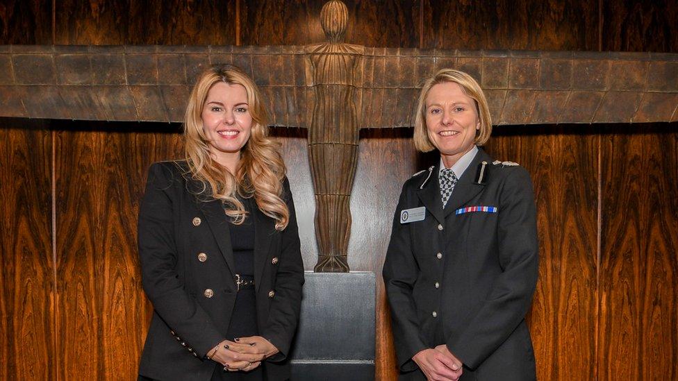 Kim McGuinness and Vanessa Jardine stand next to each other in front of a model of the Angel of the North