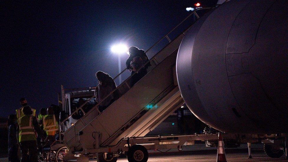 Passengers evacuated from Afghanistan disembark a British military transport aircraft at RAF Brize Norton station in southern England on August 26, 2021