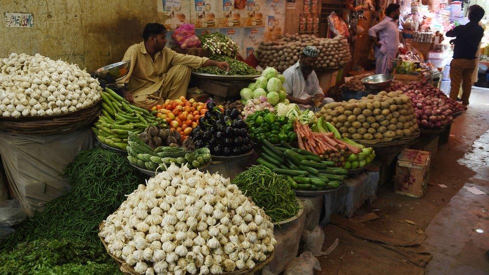 Pakistani vendors wait for customers at a market in Karachi on October 9, 2018.