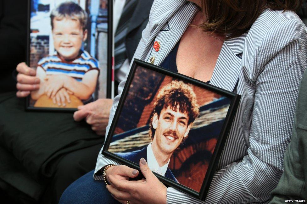 People holding photographs of some of the people who died at Hillsborough