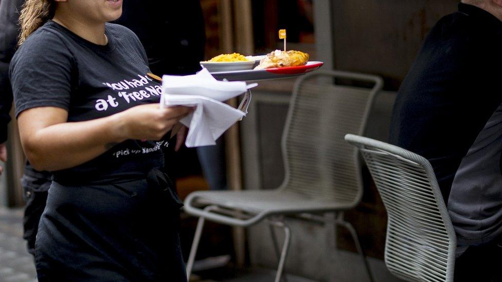 Member of staff delivers food at a Nando's