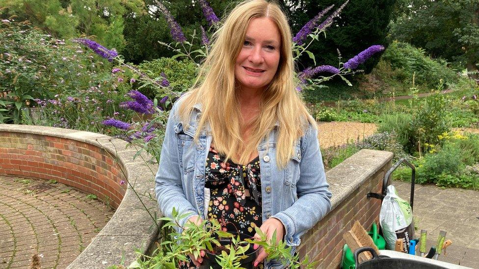 Elaine Cronin holding a plant in Bedford