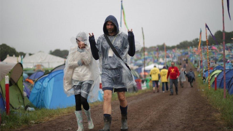 Festival goers walk in the rain at the Glastonbury Festival at Worthy Farm in Pilton, Somerset. (taken Sat 24 June)