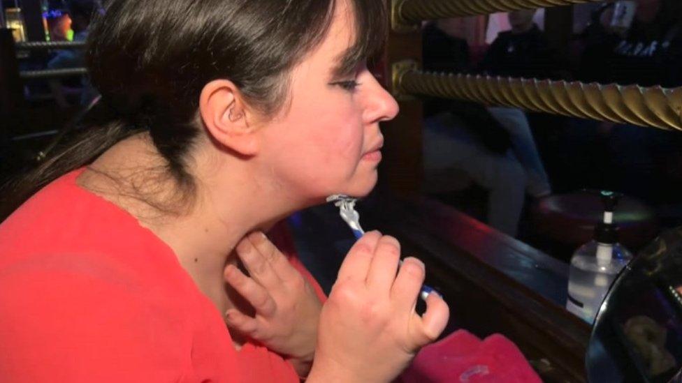 Jennie Stevenson shaving her face in a pub