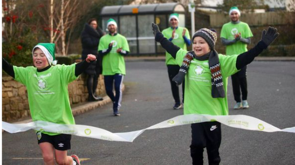 Freddie finishing his last Christmas Day run in 2020, with Hughie cheering him on