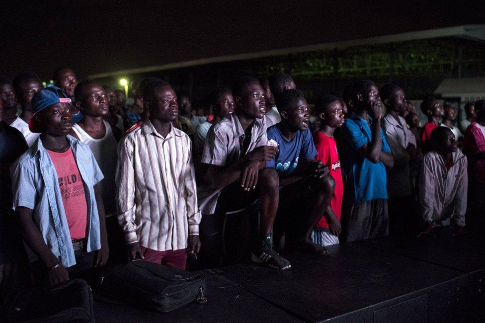 People watch a documentary called 'Number 12' by investigative journalist Anas Aremeyaw Anas about former Ghanaian Football Association (GFA) president Kwesi Nyantakyi, at Trade Fair Centre in Accra on June 10, 2018.