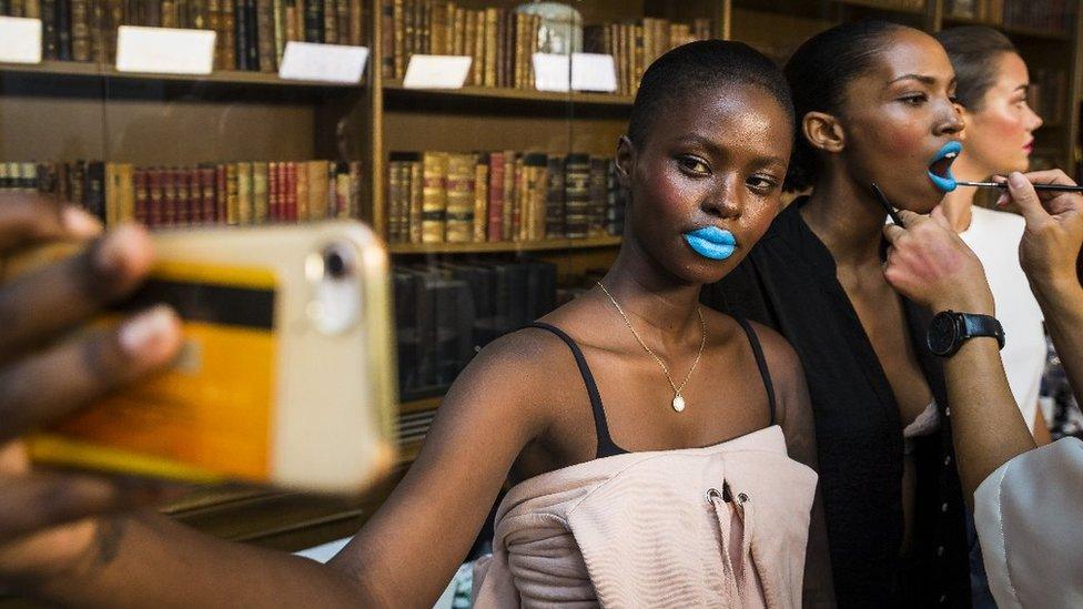 A model takes a selfie backstage on the second day of Fashion Week Stockholm