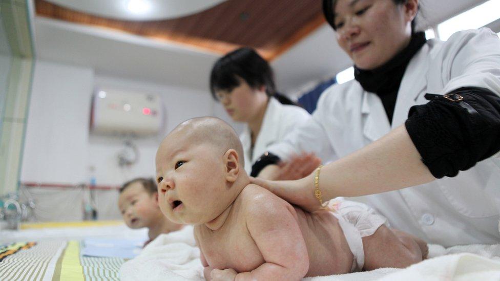 Medical staff massaging babies at an infant care centre in Yongquan, in Chongqing municipality, in southwest China