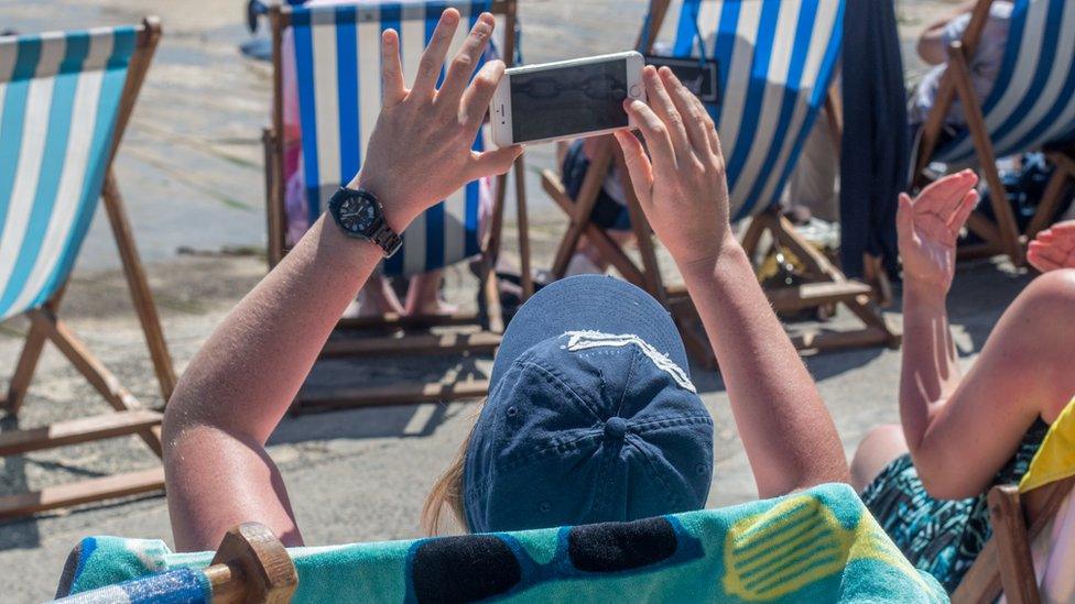 Person using mobile phone on beach