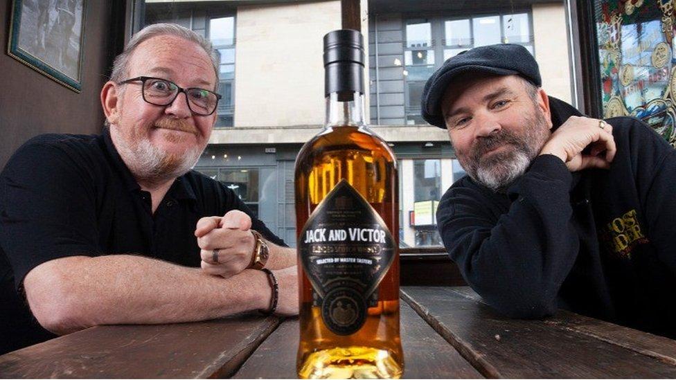 Greg Hemphill and Ford Kiernan with a bottle of Jack and Victor