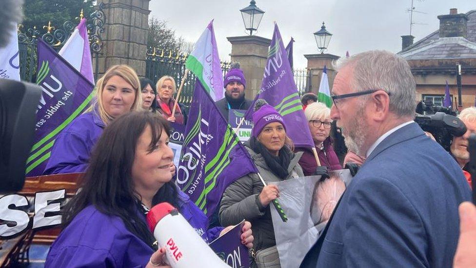 Ulster Unionist leader Doug Beattie talks to health care workers outside the talks' venue