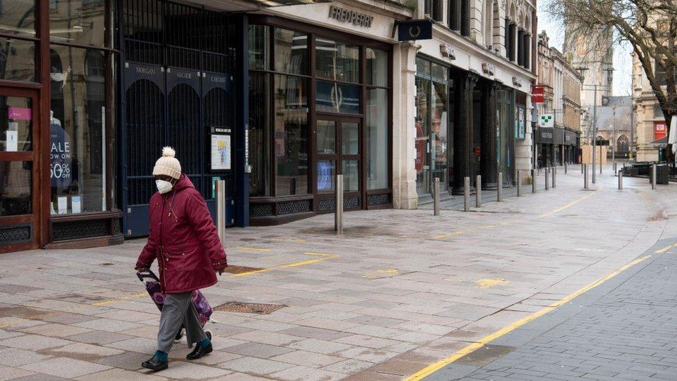 A woman walking down an empty part of the Hayes, Cardiff