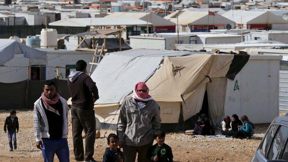 Syrian refugees watch as Britain"s Foreign Secretary Philip Hammond visits Al Zaatari refugee camp in the Jordanian city of Mafraq, near the border with Syria, February 1, 2016