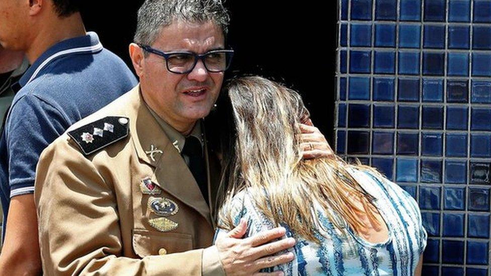 Police comfort a woman at the scene of the shooting