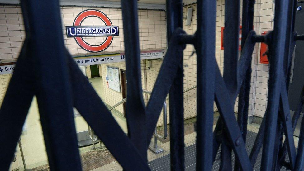 Underground sign seen through closed gates