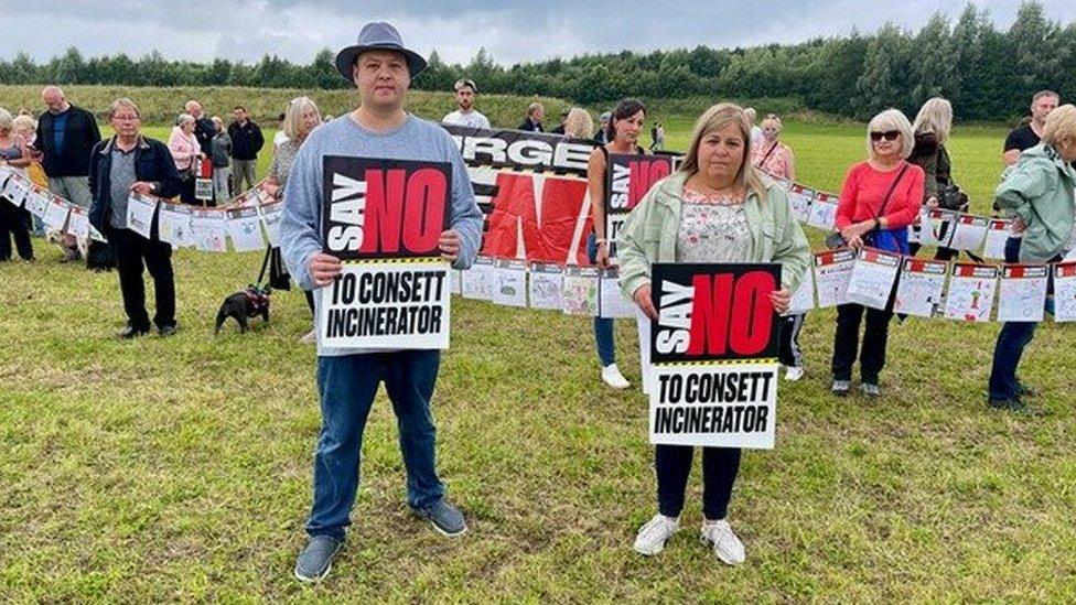 Protesters hold signs