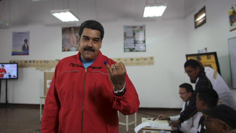 Nicolas Maduro shows his ink-stained finger after casting his vote