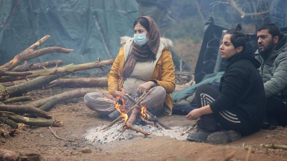 Migrants sit by the fire near Belarus' checkpoint of Bruzgi near the Polish border. Photo: 11 November 2021