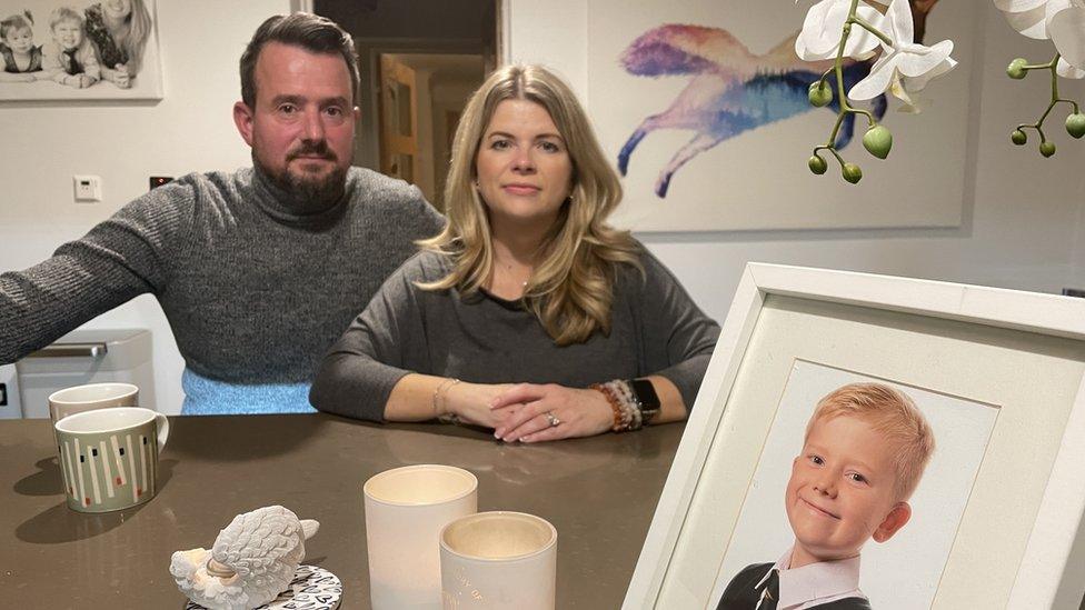 Matt and Louise Fox sat next to each other with a framed photo of their son George in front of them