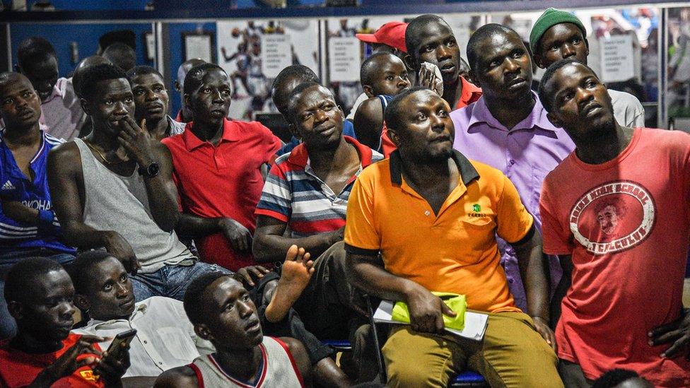 Men watching television in Ugandan betting shop